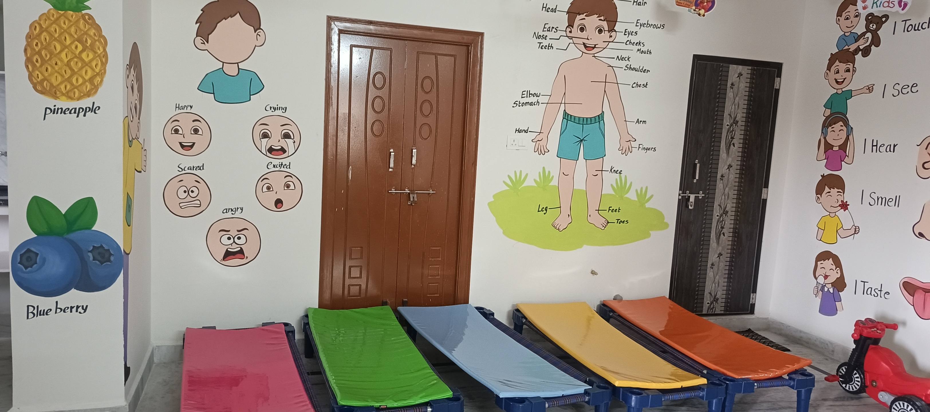 Bright classroom with colorful foam mats, tables and science-themed cartoon murals