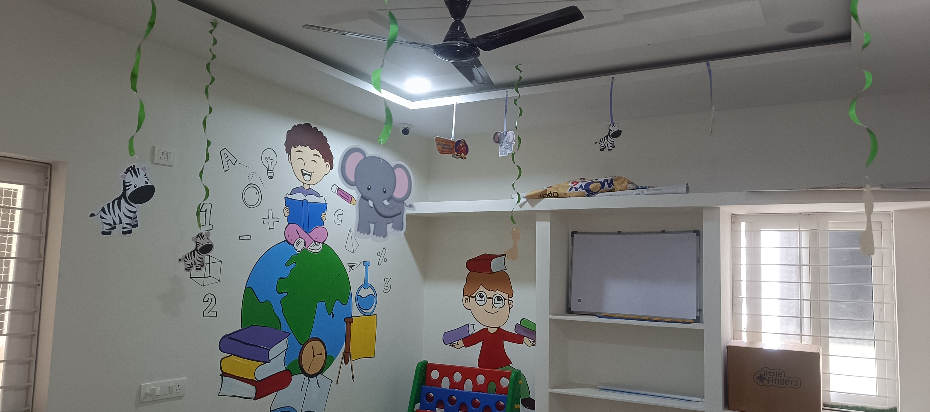 Vibrant classroom with rainbow, numbers and nature murals, and colorful chairs and table